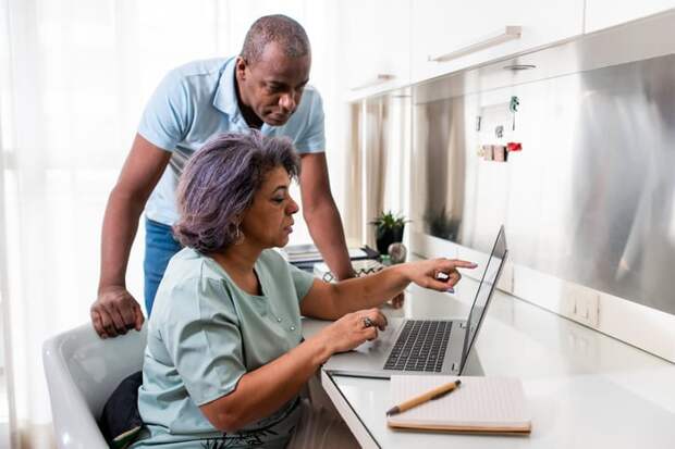 Two people looking at something on a laptop.
