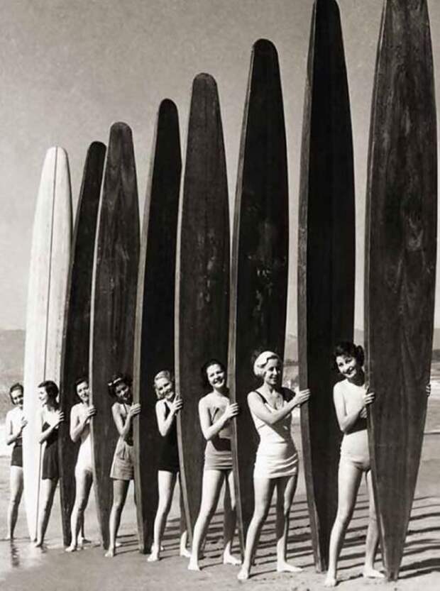 Девушки с большими досками для серфинга в начале XX века.