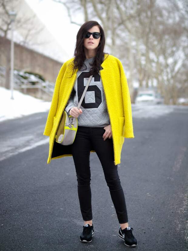 Девушка в кроссовках и желтом пальто