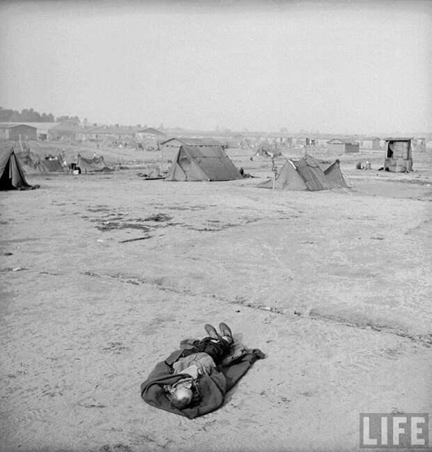 Тело, лежащее на земле в только что освобожденном лагере Берген-Бельзен.