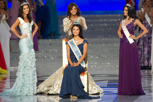 Miss World 2012 winner Yu Wenxia (C) of China receives the crown from previous winner Ivian Sarcos of Venezuela (top C) as second place contestent Miss Wales Sophie Moulds (L) and third place Miss Australia Jessica Kahawaty (R) watch, during the pageant's final ceremony at the Ordos Stadium Arena in the inner Mongolian city of Ordos on August 18, 2012. China's Yu Wenxia of China defeated more than 100 other hopefuls at the glittering ceremony held in the Chinese mining city of Ordos, on the edge of the Gobi desert. AFP PHOTO / Ed Jones