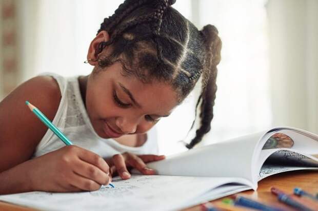 Child coloring in activity book.