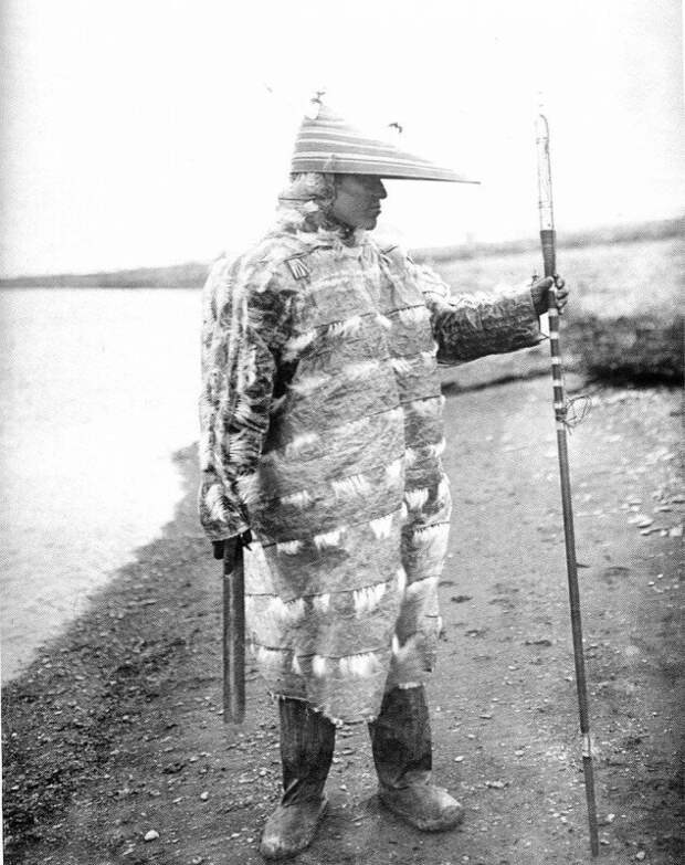 Алеут-охотник в традиционной непромокаемой одежде из кишок морского льва, Аляска, 1905 год. история, ретро, фото