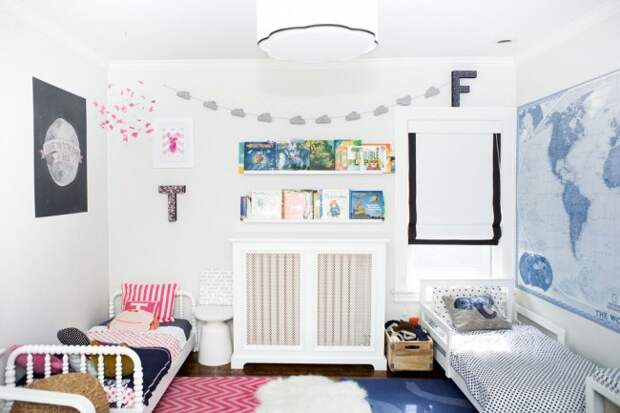 Общий выдержанный стиль детской комнаты с двумя индивидуальными спальными местами. Розовый цвет, мягкие игрушки и бабочки под потолком – спальное место для девочки. Синий цвет, карта мира и деревянный ящик вместо прикроватной тумбы – спальное место для мальчика