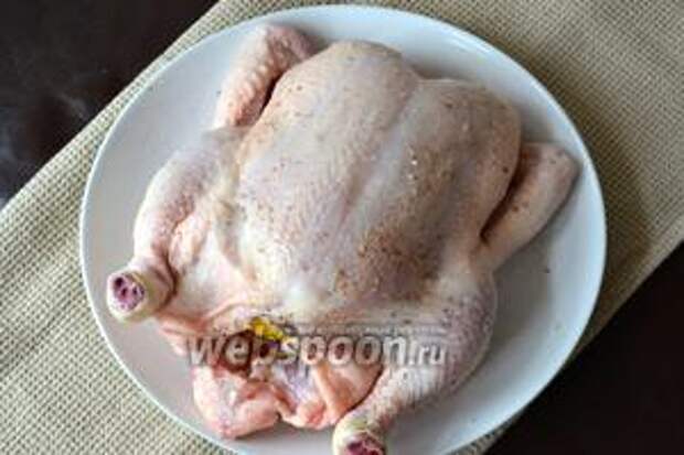 Цыплёнка вымыть и как следует обсушить бумажным полотенцем. Натереть цыплёнка изнутри и снаружи смесью соли, перца и специй. Лимон вымыть, наколоть вилкой и поместить в полость тушки. 