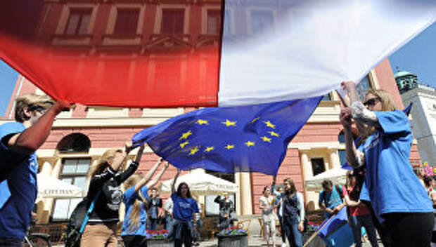 Молодые люди держат флаги Польши и Евросоюза во время демонстрации в Варшаве, Польша