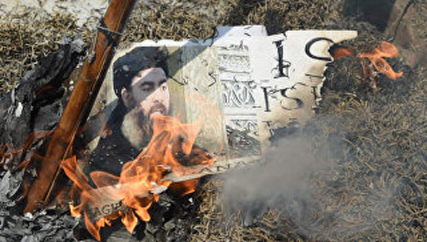 Горящая фотография лидера Исламского государства (ИГ, запрещена в РФ) Абу Бакра аль-Багдади