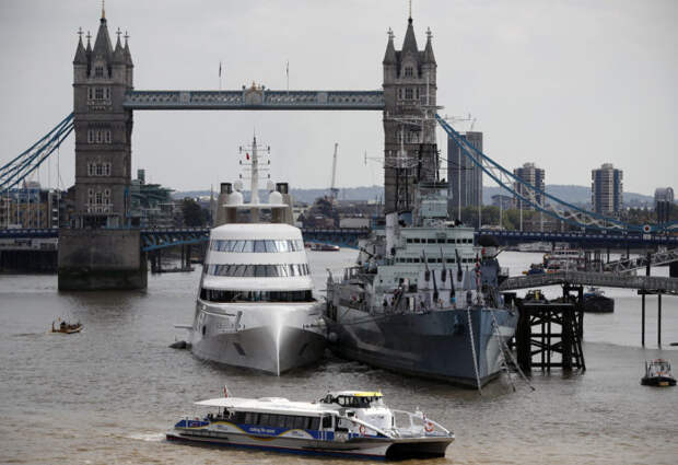 Моторная яхта «А» на реке Темза, рядом с британским крейсером HMS Belfast.