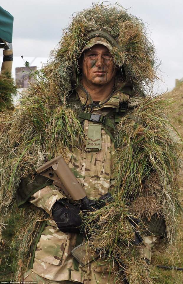 This lance corporal in the Mercian regiment is heavily camouflaged with grass as part of the war games exercise 
