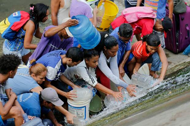 Люди собирают воду, падающую из протекающего трубопровода вдоль берегов реки Гуайер,11.03.19.png