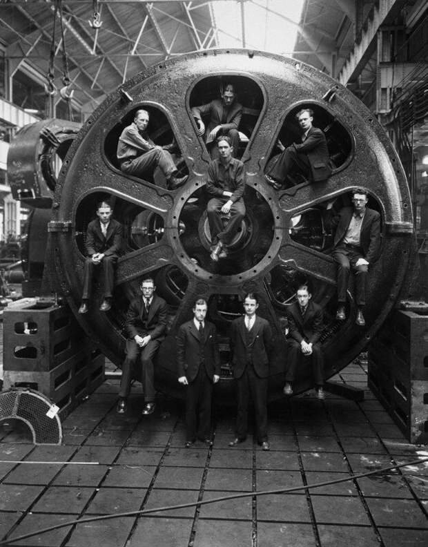 Студенты-инженеры позируют рядом с мотором, который они помогали спроектировать, на заводе компании General Electric, 1928 год. история, ретро, фото