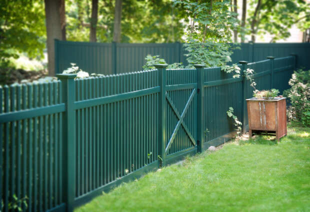 Классический штакетный забор зеленого цвета может стать красивым декоративным дополнением к ландшафтному дизайну. 
