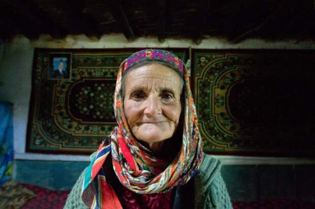 Жительница горного кишлака на Памире. На стене слева — портрет имама исмаилитов Ага-Хана IV. Фотография автора.