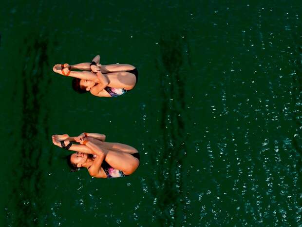 divers-plunge-into-the-mysteriously-green-pool-water