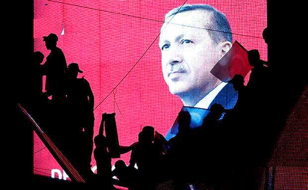 Turkish Supporters are silhouetted against a screan showing President Tayyip Erdogan during a pro-government demonstration in Ankara