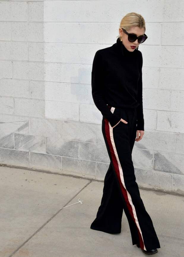 Walking in wide-leg pants with an all black outfit. 