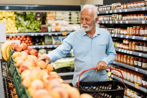 A person in a grocery store's produce aisle.