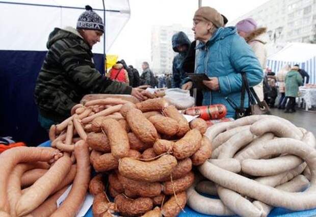 A vendor (L) sells sausage at a food market, which operates once a week on Saturday, in the Russian southern city of Stavropol, March 7, 2015. Russia's annual inflation accelerated to 16.7 percent in February, and monthly inflation rose to 2.2 percent month-on-month, the Federal Statistics Service said on March 5. Inflation in Russia has been rising steeply as a result of a slide in the rouble, which has pushed up import prices, and restrictions on many Western food imports in retaliation for sanctions imposed on Russia over the Ukraine crisis. REUTERS/Eduard Korniyenko (RUSSIA - Tags: BUSINESS FOOD SOCIETY)