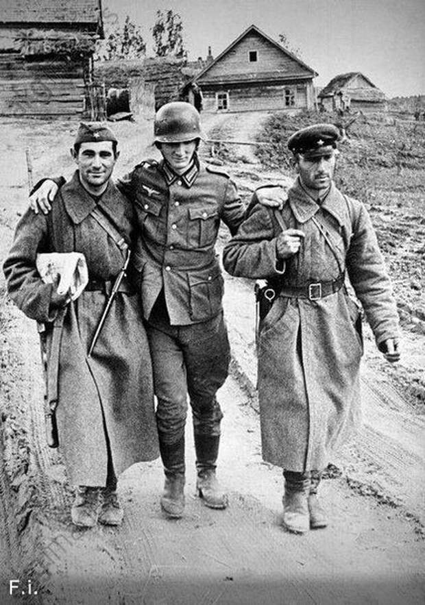Советские солдаты помогают пленному немцу идти.