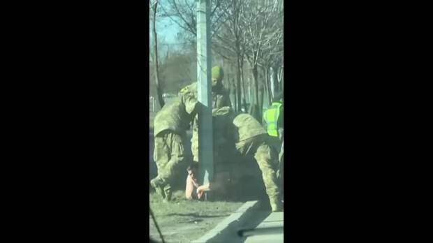 В Киеве военкомы пытались отцепить от столба мужчину, который никак не хотел садиться в микроавтобус