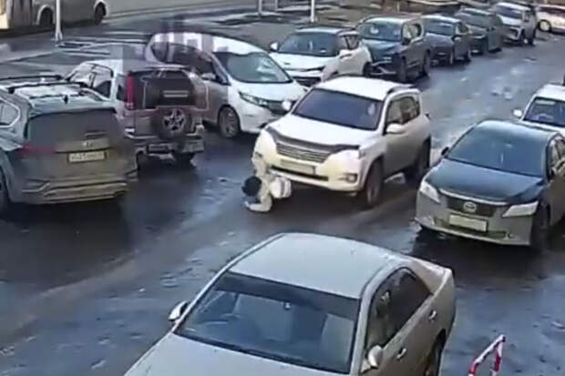 В Красноярске на видео попало, как ребенок поскользнулся и улетел под кроссовер