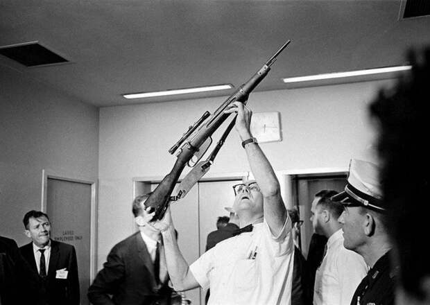 Полицейский демонстрирует винтовку из которой был убит президент США Джон Ф. Кеннеди, Даллас