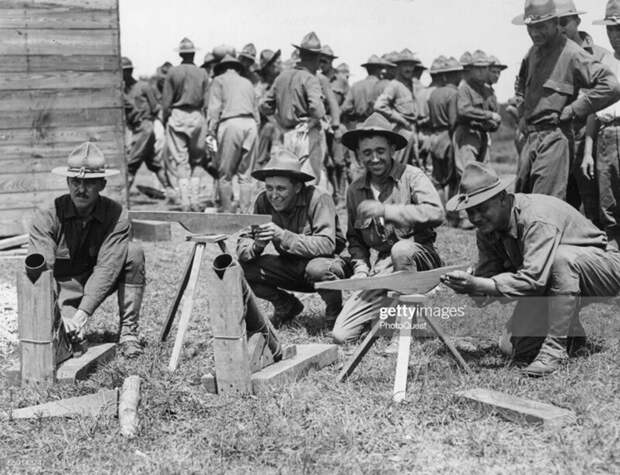 Американские пехотинцы с макетами пулемётов и миномётов, использовавшихся для обучения личного состава до поступления штатного вооружения.