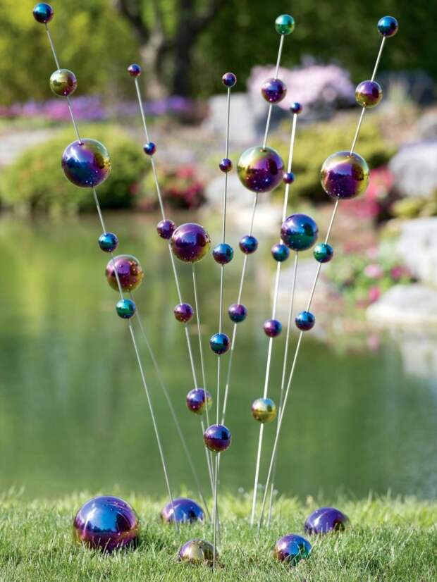 Переливающиеся небольшие шары, нанизанные на металлические прутья придадут космический эффект вашему саду