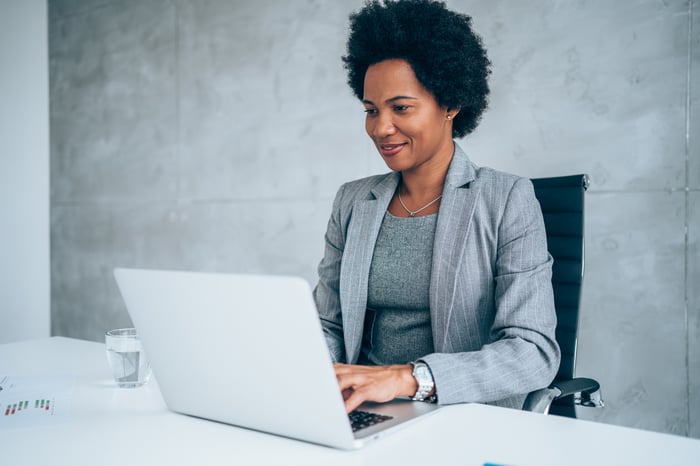 A person in professional attire at a laptop.