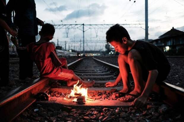 2. Дети играют с огнем на действующих железнодорожных путях в трущобном районе недалеко от станции Jakarta Kota. Другой площадки для игр у них нет бедность, джакарта, железная дорога, индонезия, нищета, репортаж, трущобы