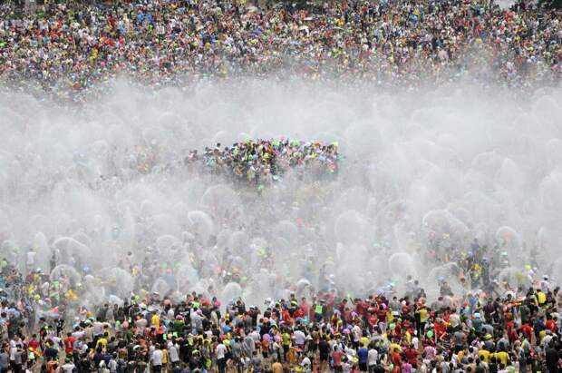 Участники ежегодного фестиваля в честь Нового года в провинции Юньнань по традиции поливаются водой.  китай, люди, население
