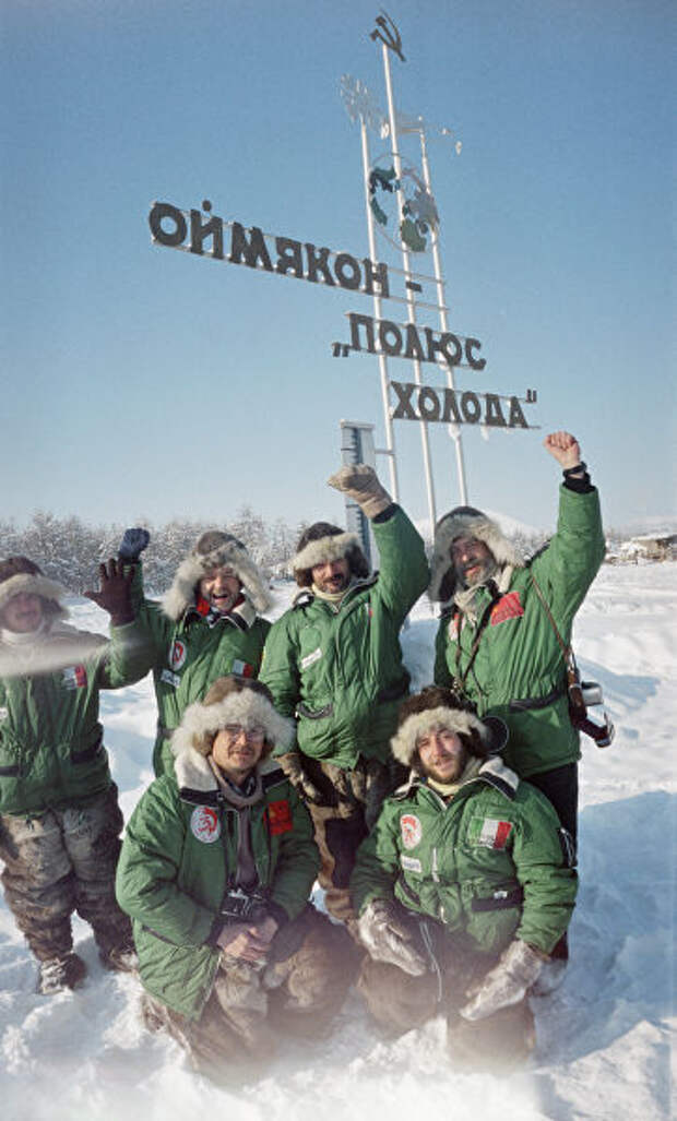 Туристы стоят у памятного знака Оймякон — полюс холода Туристы стоят у памятного знака Оймякон — полюс холода