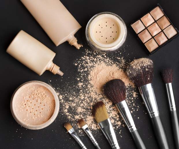 brushes, powder, makeup foundation on black