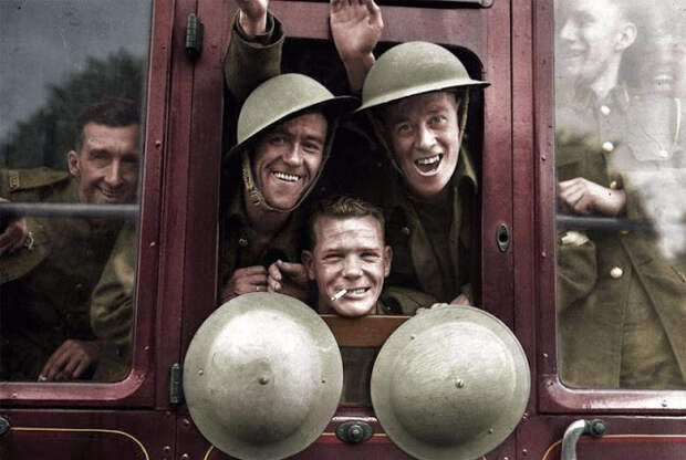 Военные улыбаются из окна поезда во время отправки на Западный фронт.