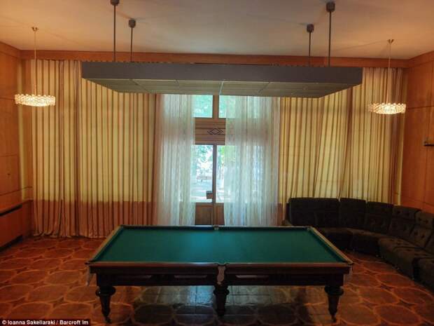Игровая комната с деревянным бильярдным столом, окнами от потолка до пола и огромным диваном. вождь, дача, фото