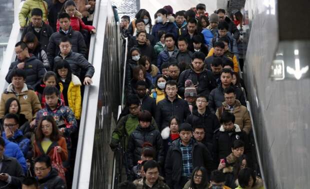 Толпа людей спускается по эскалатору и лестнице в час пик на станции метро в Пекине. китай, люди, население