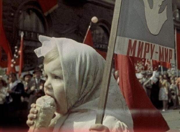 Девочка кушает мороженное на параде, который посвящён дню международной солидарности трудящихся.