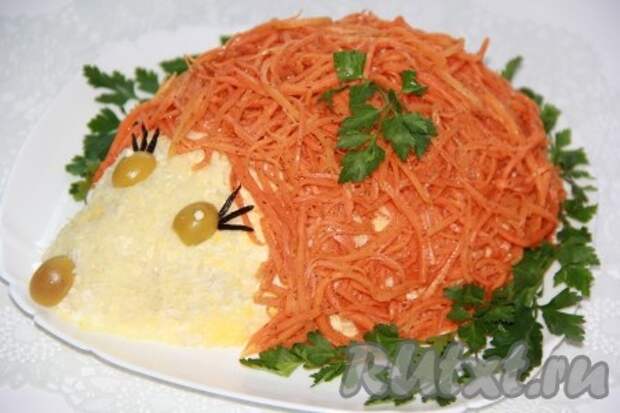 Выкладываем корейскую морковь поверх салата в виде "иголок", делаем глазки и носик нашему ёжику и ставим в холодильник на 1-2 часа. Перед подачей салат с курицей, грибами и корейской морковью украшаем зеленью. Блюдо получается очень вкусным! 
