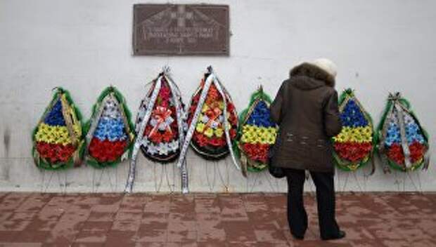 Женщина у памятной доски В память о соотечественниках, вынужденных покинуть Родину в 1920 году на Графской пристани в Севастополе