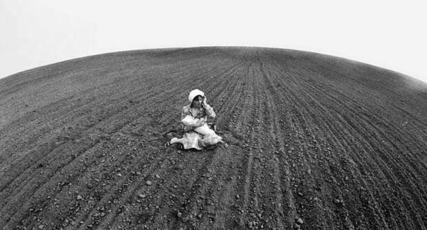 Женщина с ребенком на руках посередине вспаханного поля. 1987 год.