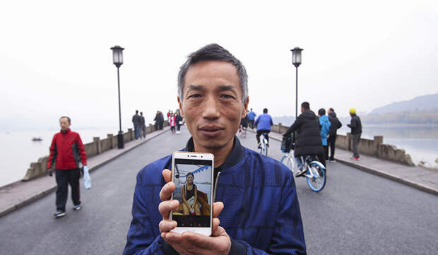 Сю показывает фотографию Кэти на своем мобильном телефоне, стоя на Сломанном мосту.