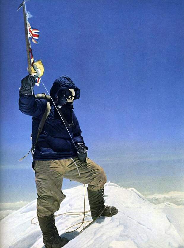 Почти двухметрового роста новозеландец Эдмунд Хиллари сфотографировал малорослого шерпа на снежном куполе с поднятым ледорубом, украшенным флажками ООН, Великобритании, Непала и Индии