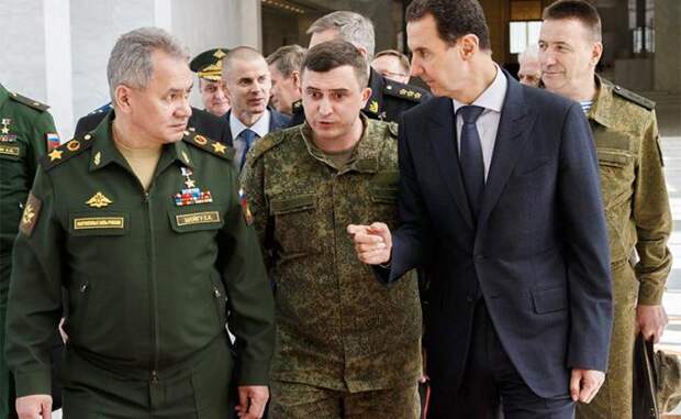 На фото: министр обороны РФ Сергей Шойгу (слева) и президент Сирийской Арабской Республики Башар Асад (справа) во время встречи