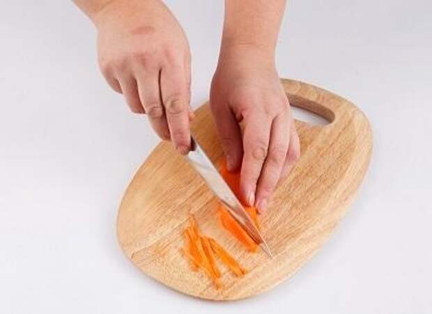 Шаг 2. На доске нарезаем морковь.