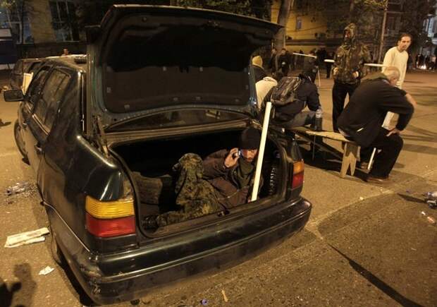 An activist rests inside the boot of a car during an overnight opposition rally in Tbilisi