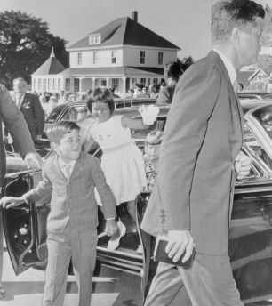 President John F. Kennedy arrives for a 9:00 A.M. Mass at St. Francis Xavier Catholic Church in Hyannis. Following their uncle to the service are (left to right) Christopher Lawford, Maria Shriver, and Sydney Lawford.