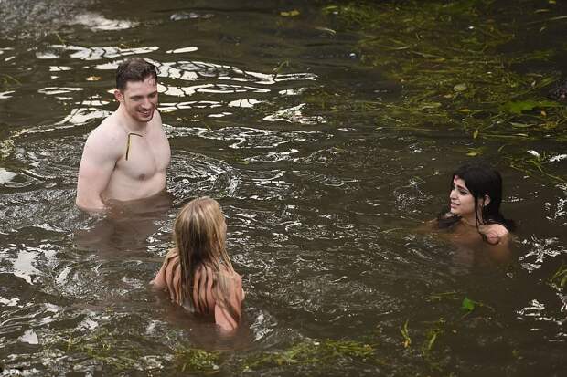 Come on in, the water's lovely! Three friends strip down to their underwear to cool off in the river after the all-night affair