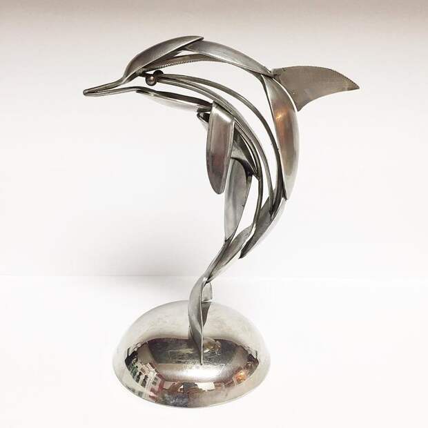 A leaping dolphin, crafted from spoons.