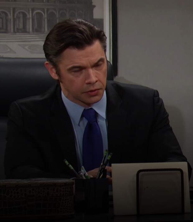 Xander sitting at his desk looking serious on Days of Our Lives