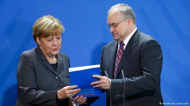 Ангела Меркель принимает из рук руководителя группы экономических советников доклад о перспективах экономики Германии